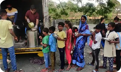 Volunteer handing over a ration kit to a woman during a food relief initiative 